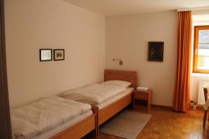 a bedroom with two beds and a window at Benediktinerstift Michaelbeuern in Michaelbeuern