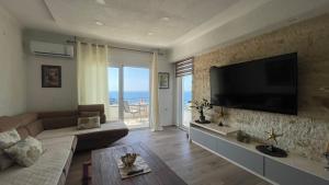 a living room with a couch and a flat screen tv at Guesthouse HHL - Liman ll in Ulcinj