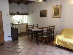 a living room with a table and chairs and a kitchen at Casaria da Adry in Cannobio