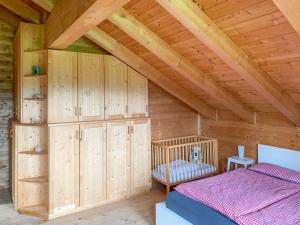 a bedroom with wooden cabinets and a bed in a attic at Allgäu Holzhaus I Bergpanorama & Natur pur im Herzen des Allgäus! in Weitnau