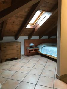 a attic bedroom with a bed and a window at Casaria da Adry in Cannobio