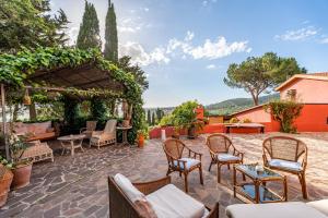 an outdoor patio with chairs and a pergola at B&B Villa il Poggetto in Venturina Terme