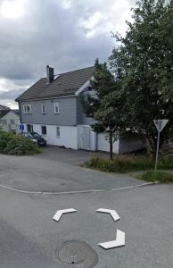 a parking lot with arrow signs in front of a house at Sentrumsnær leilighet in Trondheim