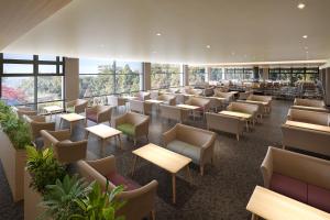 a waiting room with tables and chairs and windows at Ooedo Onsen Monogatari Premium Minoh Kanko Hotel in Minoo +12 photos
