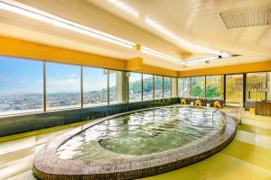 a large pool of water in a room with windows at Ooedo Onsen Monogatari Premium Minoh Kanko Hotel in Minoo