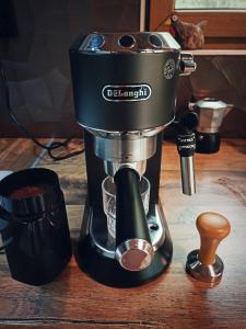 a black coffee maker sitting on a wooden table at Tinyhouse ATELIÉR u Těrlické přehrady in Horní Těrlicko