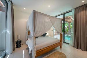 a bedroom with a bed with mosquito net at Sealuna Villas in Tanah Lot +172 photos