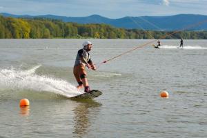a man is water skiing on a lake at Tinyhouse ATELIÉR u Těrlické přehrady in Horní Těrlicko