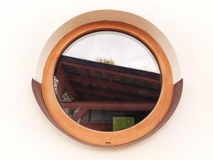 a round window with a wooden frame on a white wall at Tinyhouse ATELIÉR u Těrlické přehrady in Horní Těrlicko