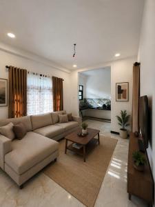 a living room with a couch and a bed at Suriya villa in Poddala