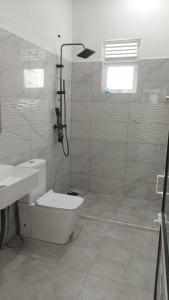 a bathroom with a shower and a toilet and a sink at Suriya villa in Poddala