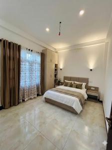 a bedroom with a large bed and a large window at Suriya villa in Poddala