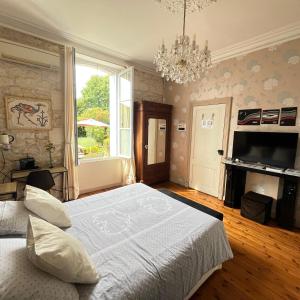 a bedroom with a large bed and a chandelier at Saint James House in Pons +49 photos
