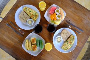 a wooden table topped with plates of breakfast food at Pondok Ijo Villa in Yogyakarta