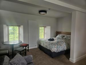a bedroom with a bed and a table and chairs at The Hedgerow Kilshanny in Kilshanny