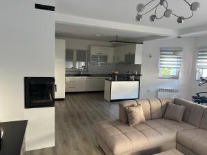 a living room with a couch and a kitchen at Sarajevo Villa Oasis in Doglodi