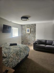 a bedroom with a bed and a couch at The Hedgerow Kilshanny in Kilshanny