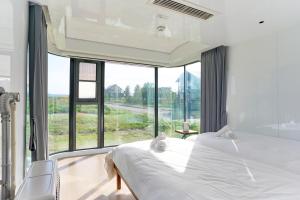 a bedroom with a bed and a large window at Straddie Island in Niseko