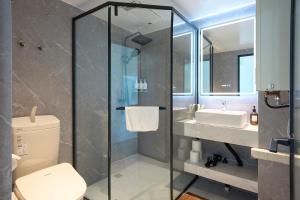 a bathroom with a shower and a toilet and a sink at Straddie Island in Niseko