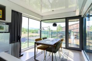 a dining room with a table and chairs and a large window at Straddie Island in Niseko +34 photos