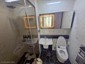 a small bathroom with a toilet and a sink at Sj라벨라 강서 in Samgong