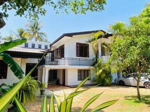 a white house with a car parked in front of it at Oracle Residence in Anuradhapura