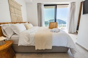 a bedroom with a bed with a large window at ELGIAN Luxury Villa -Private Pool & Sea View in Póndi +58 photos