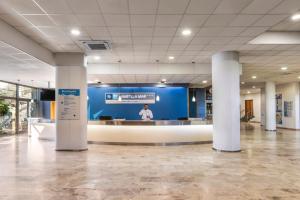 a person standing in a large room with a blue wall at RVHotels Ametlla Mar in L'Ametlla de Mar
