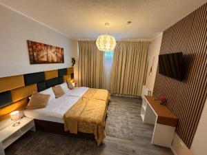 a bedroom with a large bed and a chandelier at Limo Stay in Neuhausen auf den Fildern