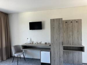 a room with a table and a tv on a wall at HILLIUS Resort in Solotvyno