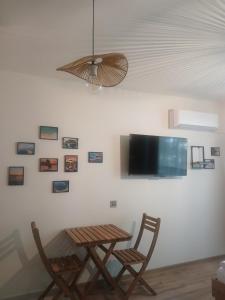 a table and two chairs and a television on a wall at Studio ONE in Kiten