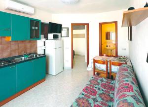 a kitchen with green cabinets and a sink and a table at VILLA ROSSINI in Valledoria