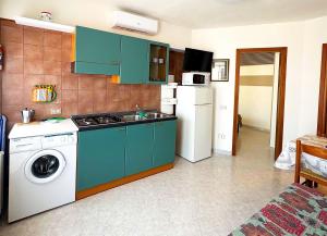 a kitchen with green cabinets and a washing machine at VILLA ROSSINI in Valledoria