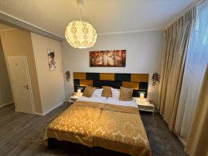 a bedroom with a large bed and a chandelier at Limo Stay in Neuhausen auf den Fildern