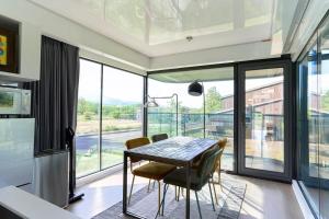 a dining room with a table and chairs and a large window at Straddie Island in Niseko