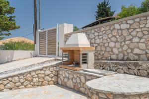 a stone wall with a brick oven on it at Ionian Home in Exanthia