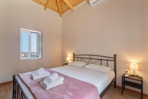 a bedroom with a bed with two towels on it at Ionian Home in Exanthia