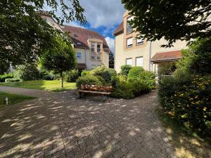 a bench sitting in the middle of a brick walkway at A Chatenois le Repère d'Anna in Châtenois