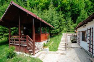 a building with a porch next to a forest at Casa Maia Dambovicioara in Dâmbovicioara +101 photos