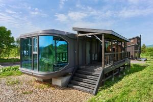 a tiny house with a porch and a deck at Straddie Island in Niseko