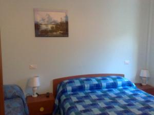 Vallo di NeraにあるHotel Ristorante Umbria Valnerinaのベッドルーム1室(ベッド1台付)が備わります。壁に絵が飾られています。