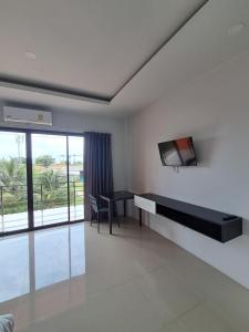 a living room with a desk and a tv on a wall at Sleek Modern Studio in Rawai, Phuket in Ban Saiyuan (1)