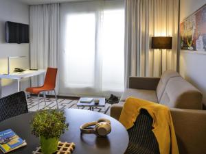 a living room with a couch and a table at Adagio Grenoble Centre in Grenoble