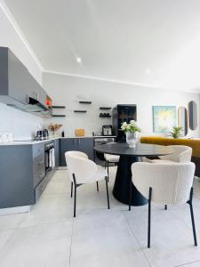a kitchen and living room with a table and chairs at Cozy and Warm-Private Queen Bedroom with Private Bathroom & shared Kitchen& Lounge in Parklands