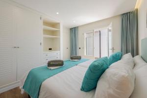 a bedroom with a large white bed with blue pillows at Apartment Vistamar IV in Port de Pollensa