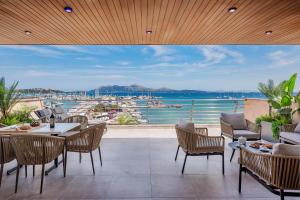 a patio with tables and chairs and a view of the water at Apartment Vistamar IV in Port de Pollensa