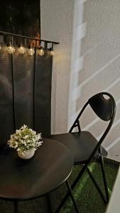 a table and a chair and a vase of flowers at Apartament IRESTAN - Komfortowy wypoczynek w sercu Karkonoszy in Jelenia Góra