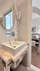 a bathroom with a white sink and a mirror at Tre R Colosseo in Rome +47 photos