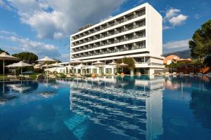 a hotel with a pool in front of a building at Airotel Achaia Beach in Patra