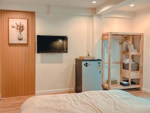 a room with a tv on the wall and a refrigerator at O2 Bangsaen in Ban Bang Saen (1)